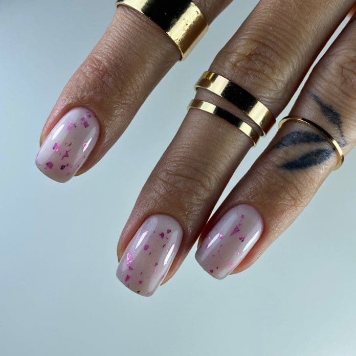 Manicure hybrydowy z mleczną bazą z różowymi drobinkami w kształcie krótkim kwadratowym zrobiony w ramach kursu podstawowego Mani Start